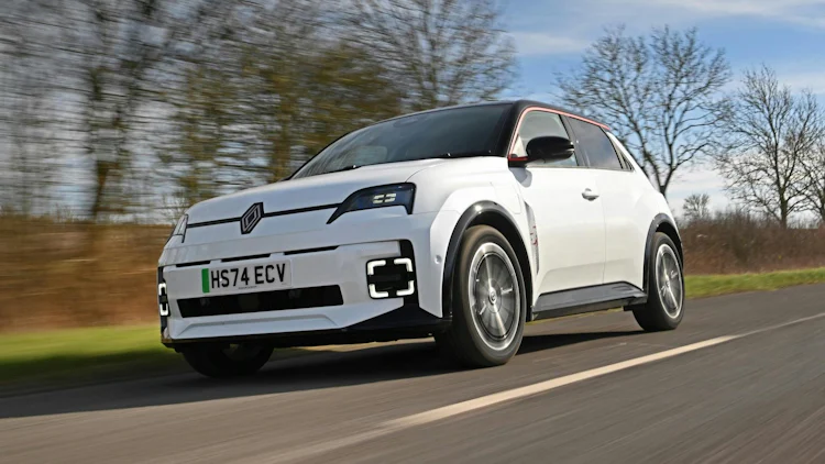 White 2025 Renault 5 driving in the countryside, front quarter angle.