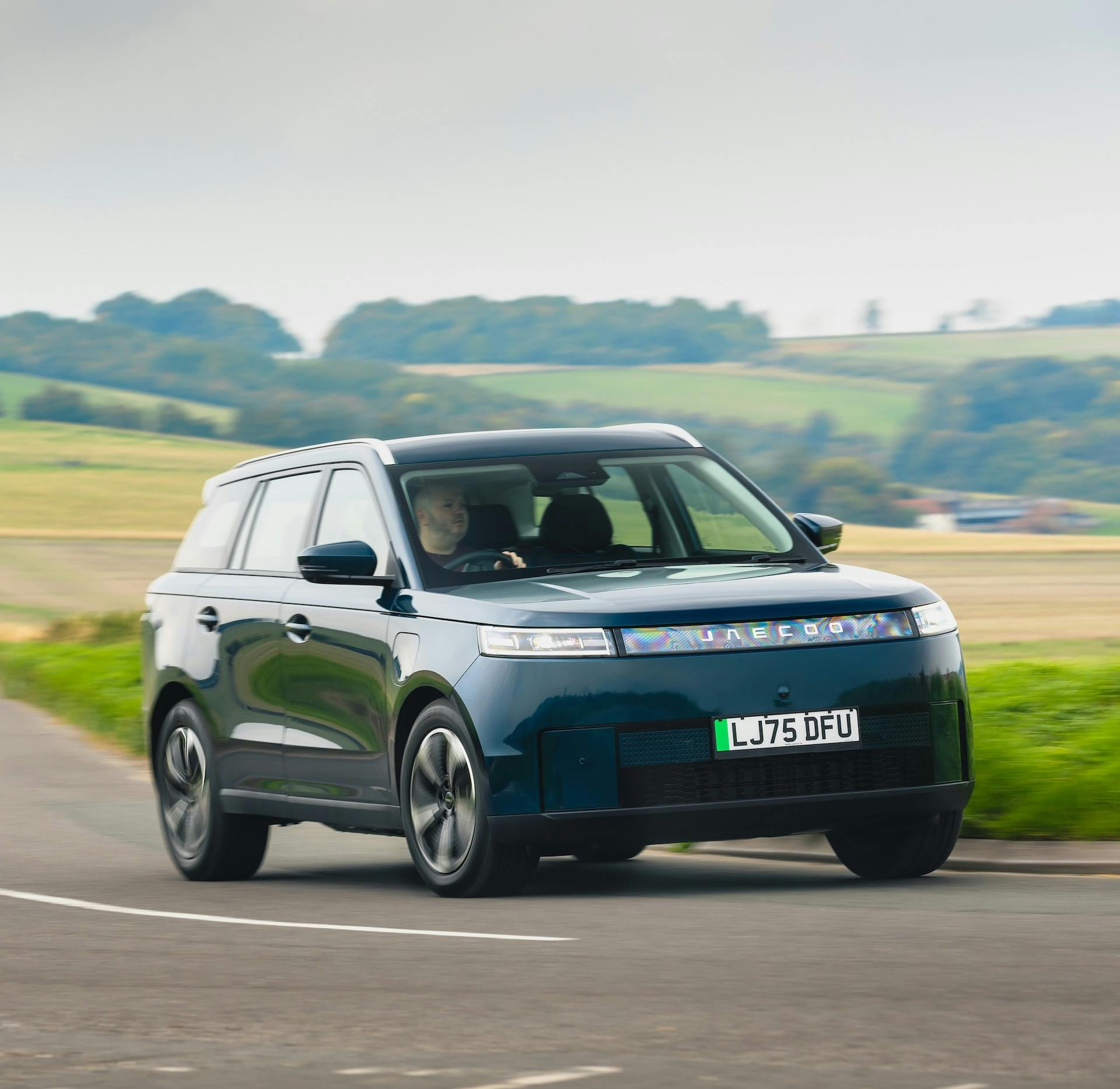 Green Jaecoo 5 driving in the countryside.